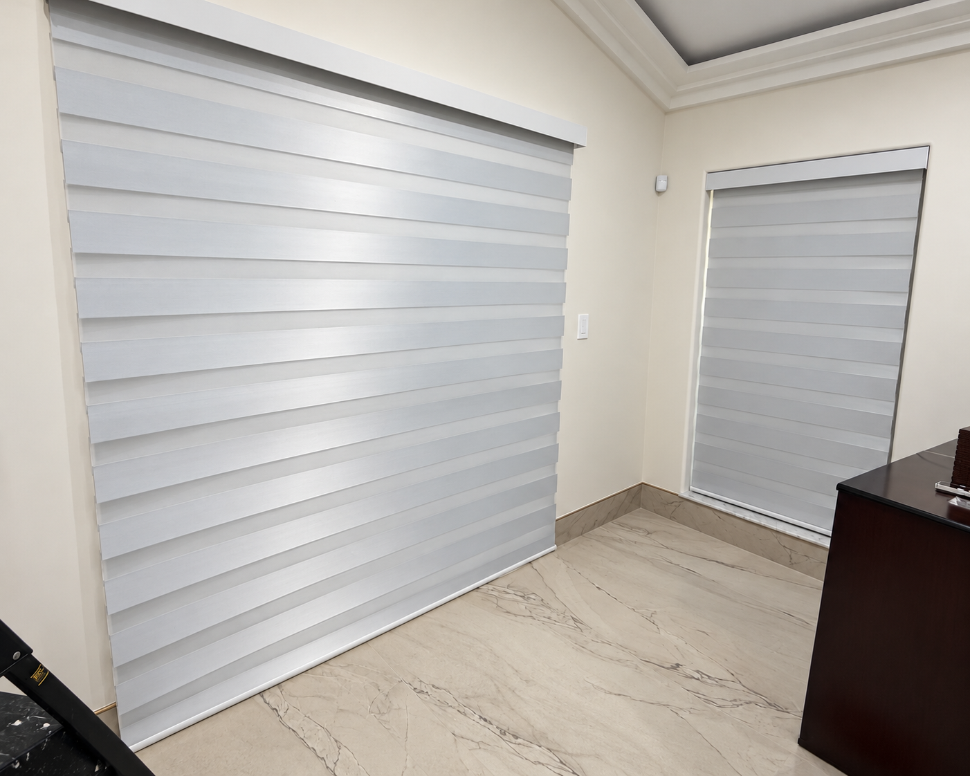 Wide and narrow motorized zebra blinds meeting at a bedroom corner in a Fort Lauderdale home