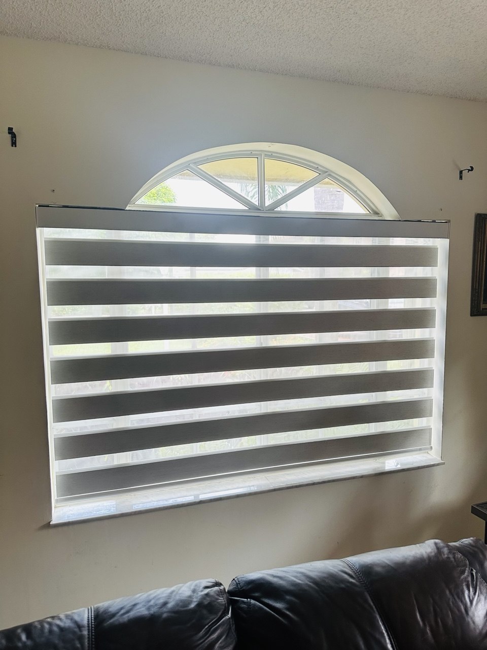 Custom motorized zebra shade on a large Miami window with arched transom