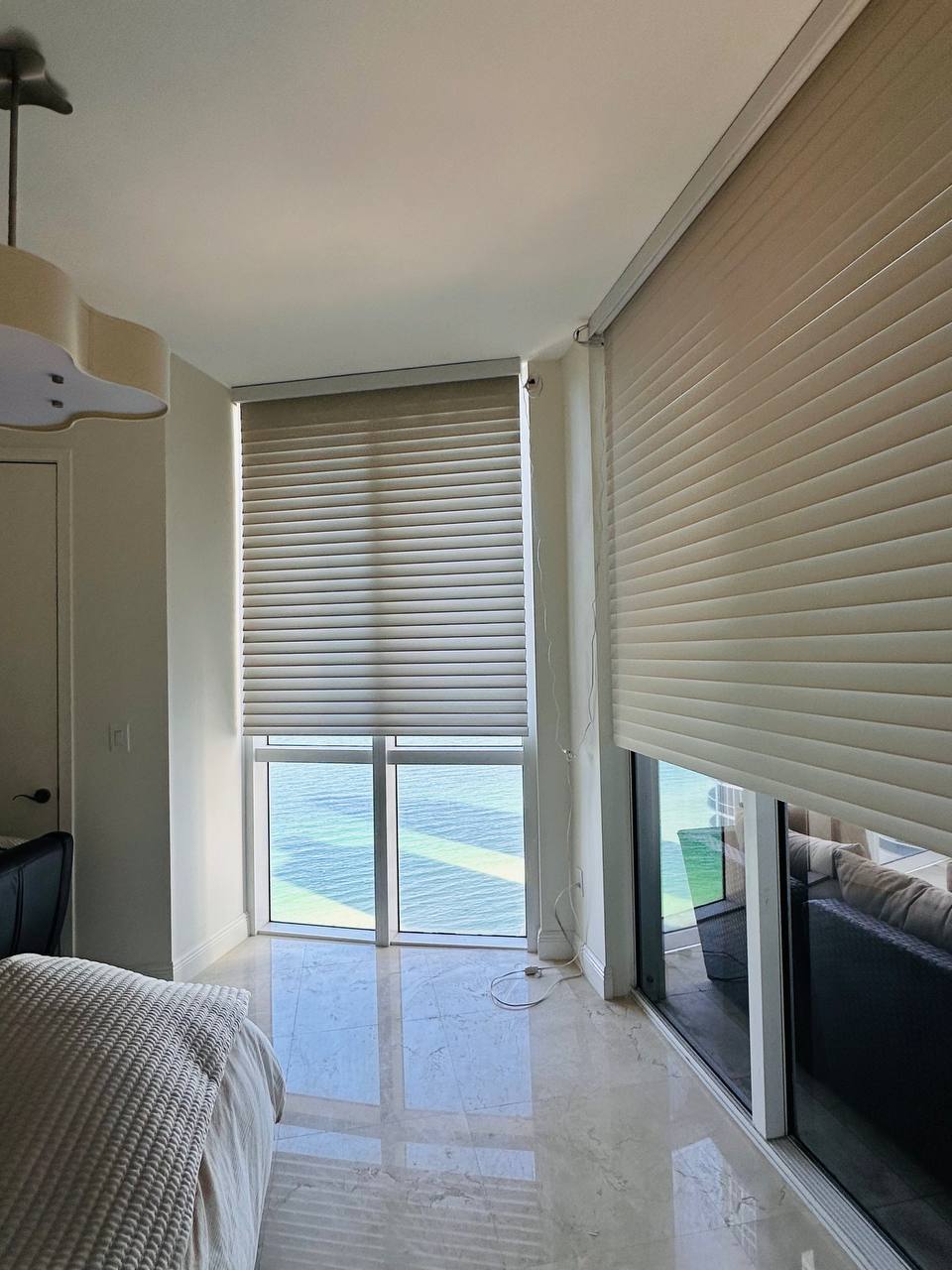 Large motorized Shangri-La shades covering floor-to-ceiling glass in a Miami condo