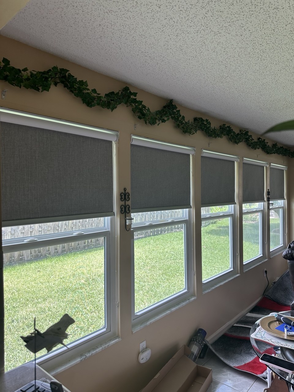 Coordinated roller shades across multiple windows in a Royal Palm Beach home