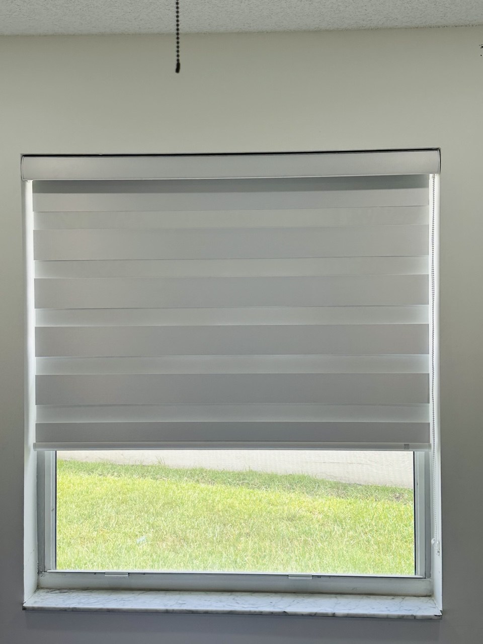 Custom zebra shade partially raised on a Fort Lauderdale bedroom window