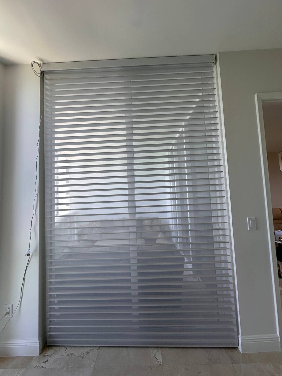 Motorized Shangri-La shade providing privacy over a large Miami condo window