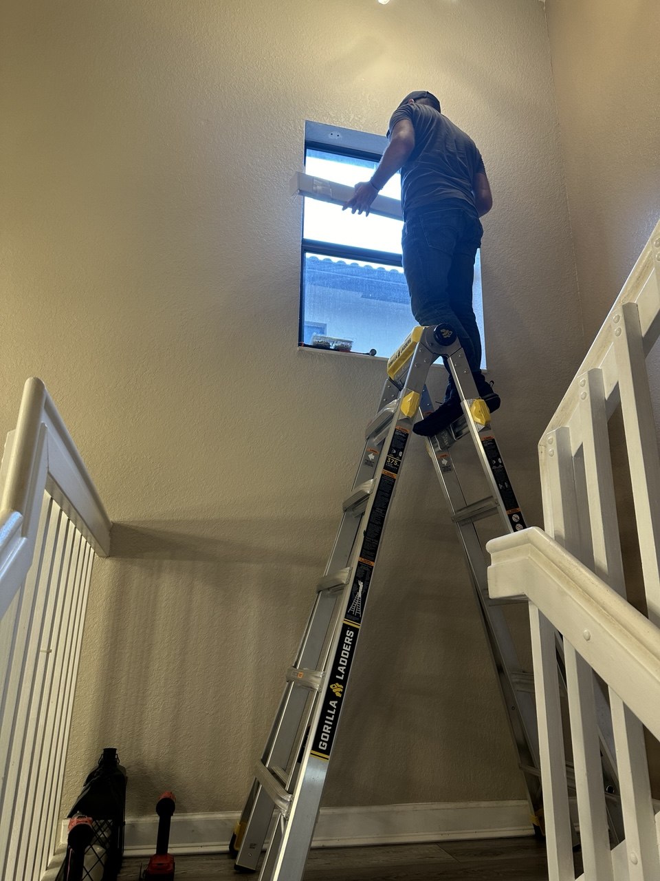Miami Smart Blinds installer fitting a zebra shade on a stairwell window