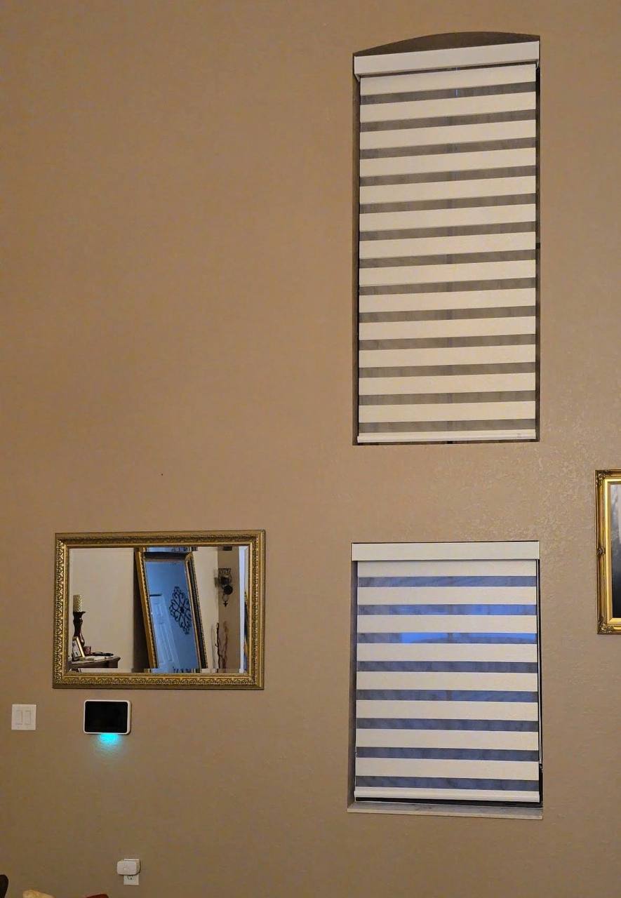 Arched and rectangular zebra shades installed on a tall wall in Kendall
