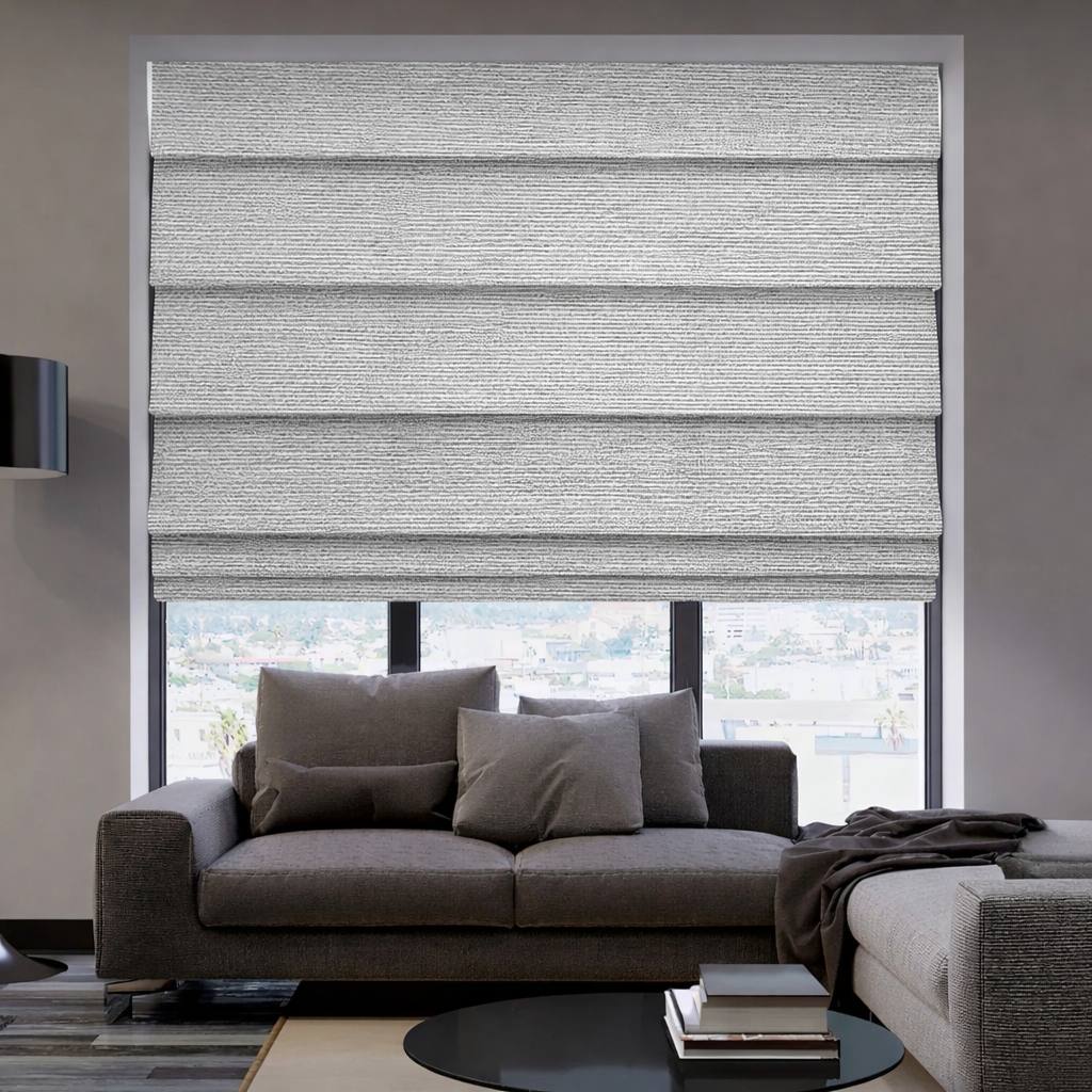 Grey roman shade over a wide living-room window behind a sofa